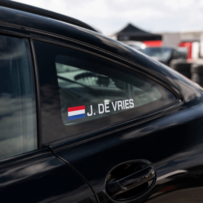 Rally naamsticker met Nederlandse vlag aangebracht op zijruit van auto