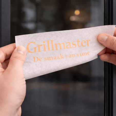 Aanbrengen van tekst sticker met applicatiepapier op glazen oppervlak