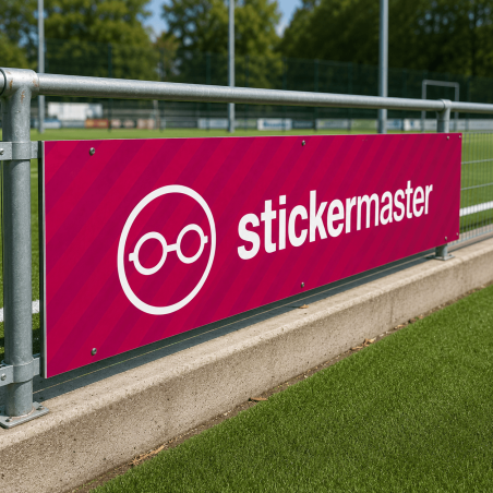 Sponsorbord met full colour bedrukking gemonteerd langs een voetbalveld op een metalen hekwerkconstructie.